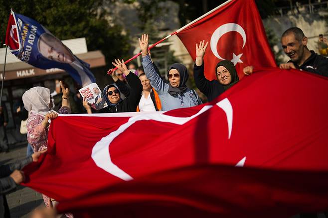 튀르키예 대선 결선투표를 나흘 앞둔 24일(현지시간) 이스탄불에서 레제프 타이이프 에르도안 튀르키예 대통령의 지지자들이 깃발을 흔들고 있다./ AP 연합뉴스