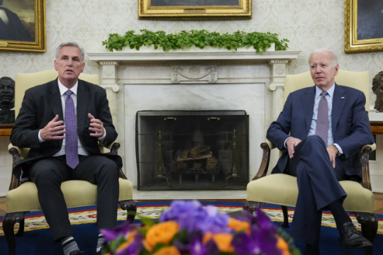 조 바이든(오른쪽) 미국 대통령과 공화당 소속 케빈 매카시 하원 의장이 22일 정부 부채한도 상한 문제 협의를 위해 백악관 오벌오피스에서 만나고 있다. AP 연합뉴스