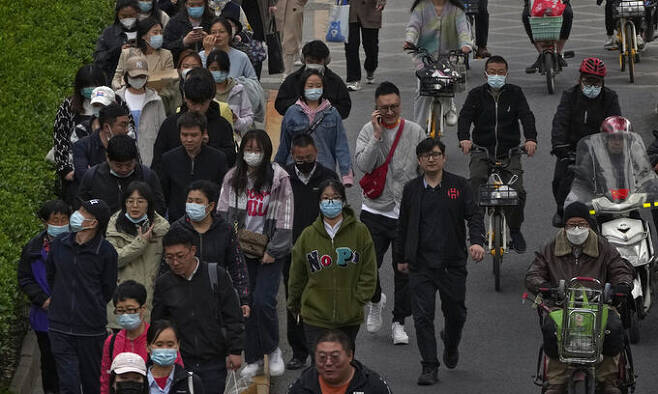지난달 26일 중국 베이징의 한 거리에서 시민들이 이동하고 있다. AP연합뉴스