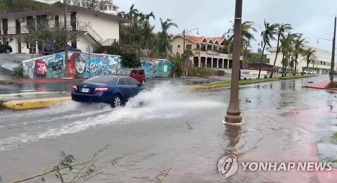 괌 강타한 '슈퍼 태풍'으로 침수된 거리 지나가는 자동차 시속 241㎞의 돌풍을 동반한 '슈퍼 태풍' 마와르가 태평양의 미국령 괌을 강타한 지난 25일(현지시간) 한 자동차가 투몬 만의 침수된 거리를 지나가고 있다. 당국은 이번 태풍으로 인한 인명 피해는 없으나 전체 5만2천 가구·상업시설 중 1천 곳에만 전기가 공급되는 등 단전 및 단수의 피해가 막대하다고 전했다. 2023.05.28
[AFP 연합뉴스 자료사진. 재판매 및 DB 금지]