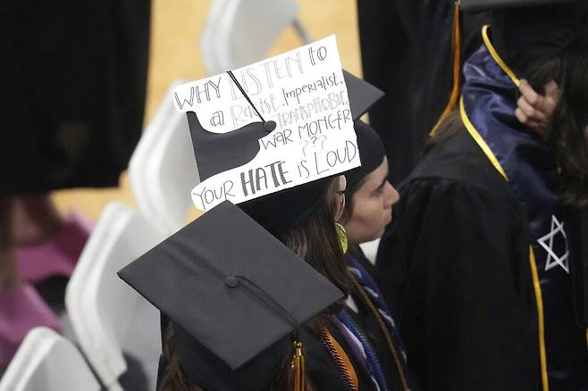한 학생이 리즈 체니 전 하원의원에게 항의하는 메시지가 붙은 졸업 모자를 쓰고 있다. 메시지엔 “인종차별주의자이며 제국주의자이고 성전환혐오자이며 전쟁광인 자의 말을 왜 들어야 하는가?”라고 적혀있다. AP 연합뉴스