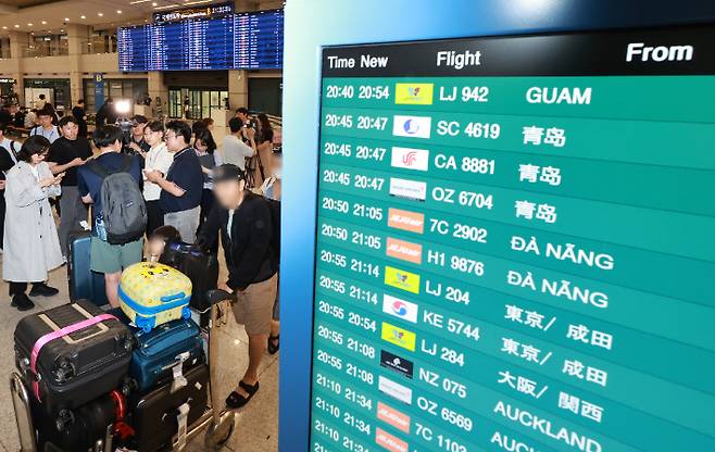 태풍 '마와르' 영향으로 괌에 고립됐던 한국 관광객들이 괌 국제공항 운영 재개로 29일 오후 인천국제공항 제1여객터미널 입국장을 통해 귀국해 취재진의 질문에 답하고 있다. 연합뉴스