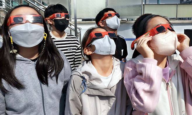 천체 관측실에서 아이들이 솔라뷰어 필름을 끼고 태양의 흑점과 홍염을 관찰하고 있다.