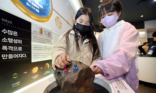 우주의 많은 정보를 갖고 있는 운석(철질)을 직접 만져보고 체험을 하고 있다.