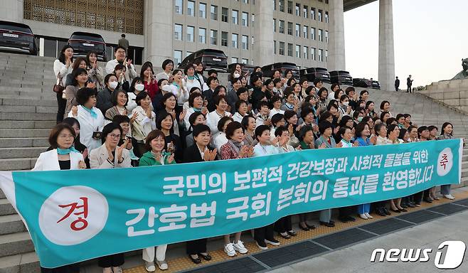 최연숙 국민의힘 의원 및 대한간호협회 회원들이 27일 오후 서울 여의도 국회 본청 앞 계단에서 현수막을 들고 간호법안(대안)에 대한 수정안 통과를 환영하고 있다. 2023.4.27/뉴스1 ⓒ News1 임세영 기자