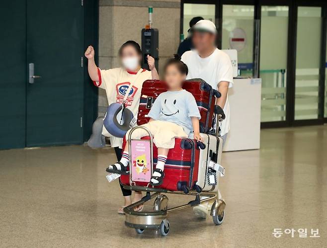 초강력 태풍 ‘마와르’가 강타한 괌 현지에서 일주일 동안 발이 묶였던 한국인 관광객들이 29일 오후 9시 반경 환한 표정으로 
인천국제공항 제1터미널 입국장에 들어서고 있다. 위 사진은 환영한다는 문구가 담긴 스케치북을 들고 공항 입국장에서 엄마를 기다리는
 김모 양(8). 외교부는 “괌 국제공항이 운영을 재개함에 따라 늦어도 31일까지는 현지에 고립됐던 한국인 관광객 3400여 명 중
 귀국을 희망하는 이들 모두가 한국에 도착할 것”이라고 밝혔다. 인천=최혁중 sajinman@donga.com·최원영 기자