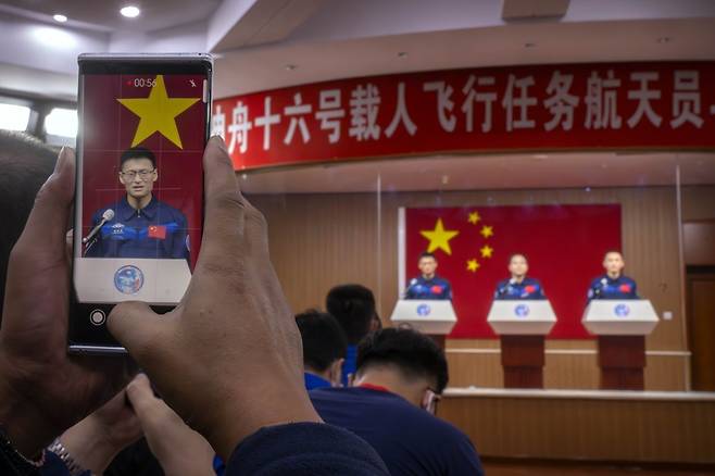 선저우 16호 발사를 하루 앞두고 29일 중국 간쑤성 주취안 위성발사센터에서 열린 기자회견에서 우주비행사들이 유리벽 뒤편에 서서 취재진에 질문에 답하고 있다. 주취안=AP 뉴시스