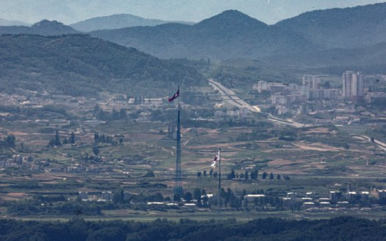 지난 29일 오후 경기도 파주시 접경지역에서 바라본 서부전선 비무장지대(DMZ)에서 남측 대성동 마을 태극기와 북측 기정동 마을 인공기가 펄럭이고 있다. 연합뉴스