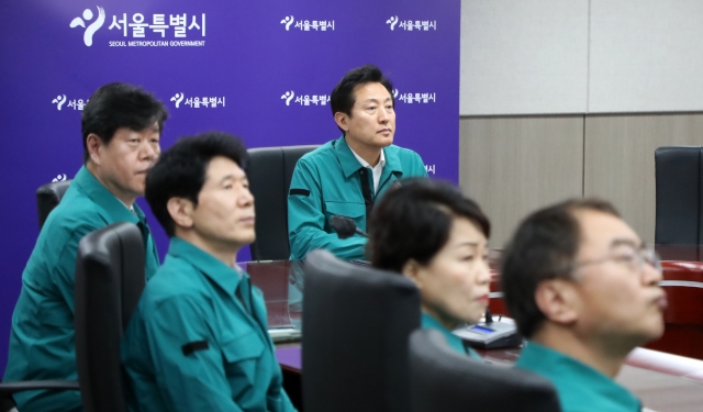 오세훈 서울특별시장이 녹색 민방위복을 입고 제414차 민방위의 날인 지난 16일 서울시청에서 실시된 민방공 대피훈련에 참석해 관련 현황 보고를 받고 있다. 뉴시스