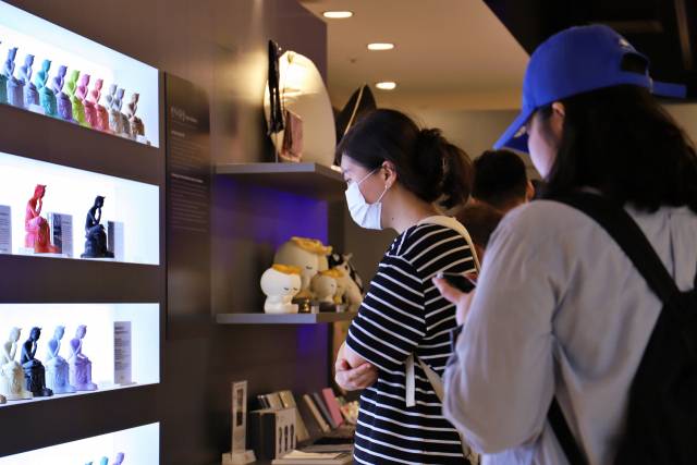 롯데백화점 서울 명동 본점에 문 연 국립중앙박물관 기념품 팝업 매장인 ‘나에게 온 보물, 뮷:즈(MU:DS : Museum Goods)’를 방문한 고객이 반가사유상 기념품 진열대 앞에서 반가사유상에 대한 설명을 읽고 있다./사진 제공=롯데백화점