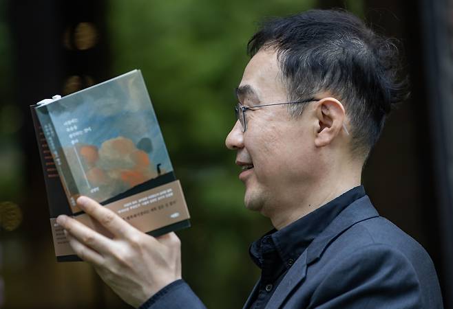 첫 산문집 ‘아침에는 죽음을 생각하는 것이 좋다’를 펼쳐든 김영민 교수. ‘안면 식별이 가능하지 않은 사진을 찍어달라’는 그의 요청에 따라 옆모습을 촬영했다. /이태경기자