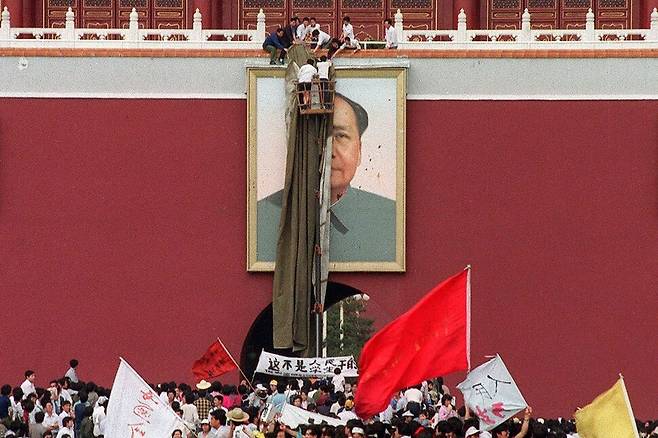 5월23일 : 시위대가 중국 공산당 건국의 아버지인 마오쩌둥의 초상화를 가리고 있다. AFP 연합뉴스