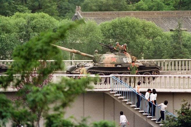 6월5일: 탱크가 들어왔다. 한 군인이 총을 들고 위협하자 시민들이 달아나고 있다. AFP 연합뉴스