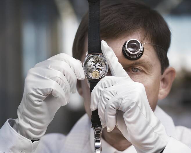 IWC의 시계 제작 장인이 시계 안팎을 직접 들여다 보며 점검하고 있다. 사진 IWC