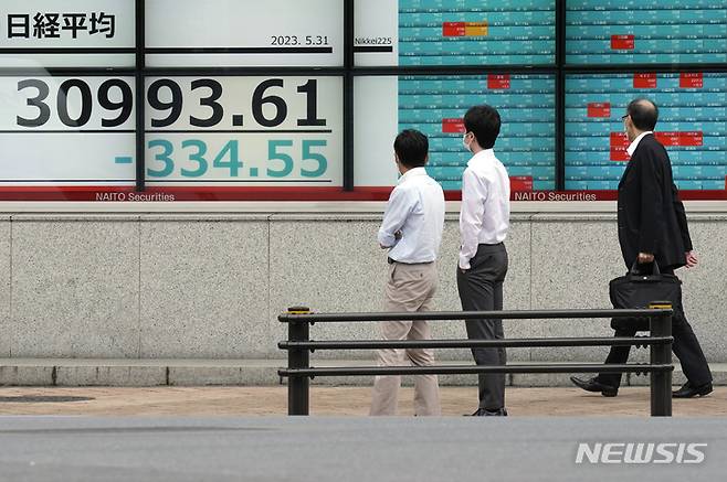 [도쿄=AP/뉴시스]31일 일본 도쿄의 한 증권회사에서 닛케이225지수를 보여주는 주식 시황판을 사람들이 지켜보고 있다. 2023.05.31.