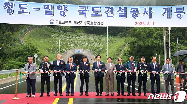1일 경북 청도군 청도읍 신도터널 입구에서 개최된 청도-밀양 국도 건설공사 개통식 참석 내빈들이 테이프를 자르고 있다.(밀양시 제공)