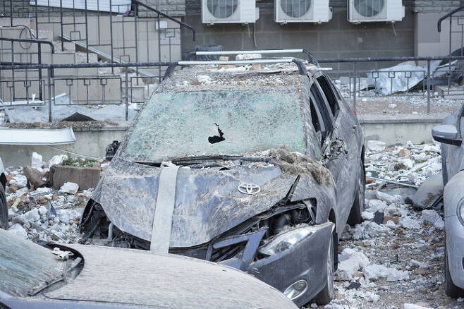 30일(현지시각) 우크라이나 수도 키이우에서 러시아군의 포격으로 차가 찌그러져 있다. 신화 연합뉴스