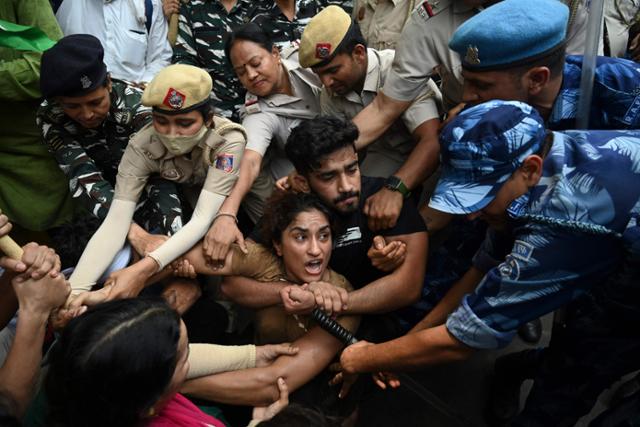 지난달 29일 인도 콜카타에서 레슬링계 거물의 성추행 혐의에 항의하는 인도 레슬러와 시위대가 경찰과 실랑이를 벌이고 있다. 콜카타=AFP 연합뉴스