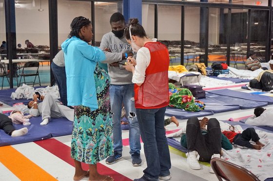 작년 12월 미국 텍사스 매켈런의 한 이민자 휴식 센터에서 한 자원 봉사자가 임신부 이민자를 돕고 있다. AP=연합뉴스