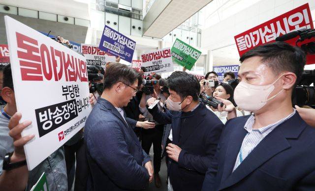 한동훈 법무부 장관의 개인정보 유출 의혹과 관련 MBC 기자 임모씨를 압수수색 중인 경찰(오른쪽)이 30일 항의하는 노조 구성원들 앞에서 신분증을 내밀며 MBC 사옥 진입을 시도하고 있다. 연합뉴스
