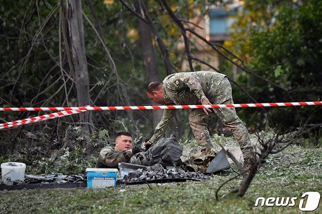 1일(현지시간) 러시아 군의 미사일 공격을 받은 우크라이나 키이우의 병원 밖에서 병사들이 미사일 잔해를 살펴 보고 있다. ⓒ AFP=뉴스1 ⓒ News1 우동명 기자
