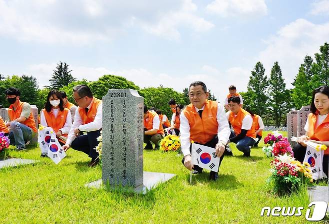 김신연 한화커뮤니케이션위원회 사장(앞줄 오른쪽 두번째)을 비롯한 한화그룹 대전·충청지역 게열사 임직원 70여명이 국립대전현충원 3사병 묘역을 찾아 봉사활동을 펴고 있다.(한화갤러리아타임월드 제공) /뉴스1