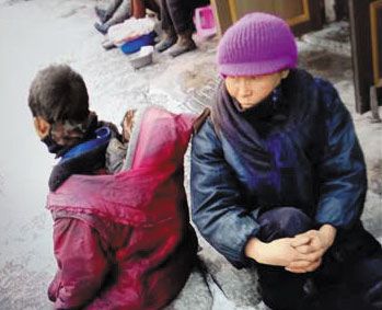 지난 3월 초 양강도 혜산시의 한 골목 시장에서 한 ‘꽃제비’ 아이(왼쪽)가 자리에 앉아 상인들이 파는 음식을 바라보고 있다. /대북소식통 제공