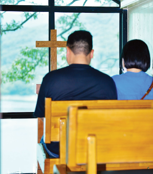 한 관광객 부부가 세상에서 가장 작은 교회당에 들어가 기도하고 있는 모습. 옥천=신석현 포토그래퍼