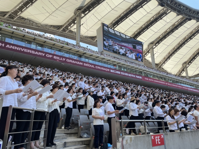 1만 명 찬양대가 3일 '빌리 그레이엄 전도대회 50주년 기념대회'에서 일어난 채 찬양하고 있다.