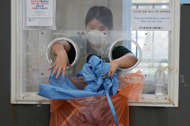 임시선별검사소 운영 중단을 하루 앞뒀던 지난 5월31일 오후 서울역광장에 마련된 임시선별검사소에서 의료진이 보호복을 정리하고 있다. ⓒ연합뉴스