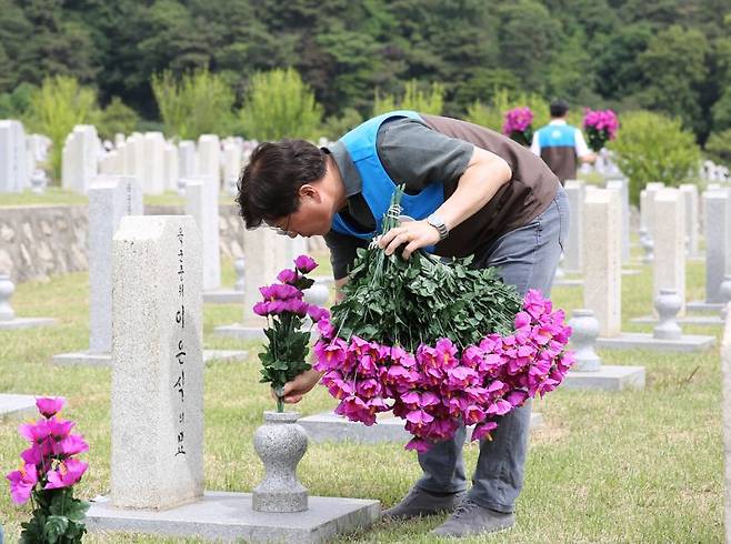 GS리테일 경영진이 지난달 제15묘역에 안장된 묘비에 꽃을 헌화하고 있다. GS리테일 제공