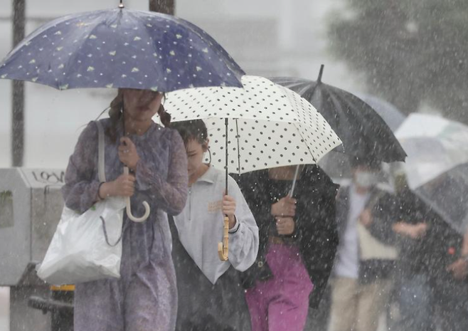 일본에서 기록적 폭우가 내려 시민들이 우산을 쓰고 있다. /사진=DW