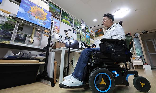 임 화가가 태블릿 PC로 사진을 보며 그림 아이디어를 얻고 있다.