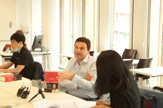 프랑스의 경제학자 토마 피케티(가운데)가 파리 시내 파리경제대 강의실에서 한국 언론과 '자본과 이데올로기' 한국어판 출간을 기념해 온라인과 오프라인으로 기자회견을 하고 있다.