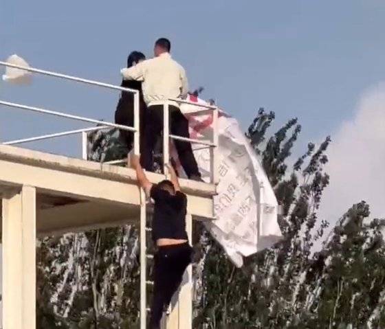 3일 베이징 올림픽 공원에서 한 여성이 성조기를 흔들려다 경비 요원들에게 저지당하고 있다. 트위터 캡쳐