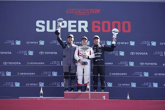 금호타이어가 후원하는 엑스타 레이싱팀이 지난 4일 전남 영암군 코리아인터내셔널서킷에서 열린 ‘2023 CJ대한통운 슈퍼레이스 챔피언십’ 3라운드 우승을 차지했다. 사진은 엑스타 레이싱팀 소속 이찬준 선수(가운데)가 우승컵을 들고 기념 촬영을 하는 모습. [금호타이어]