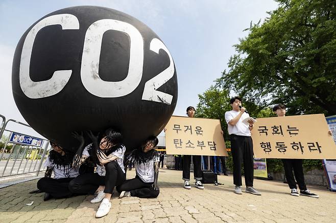 청년환경단체 회원들이 대형 탄소를 짊어지며 국회의 기후위기 대응을 촉구하고 있다. [그린피스]