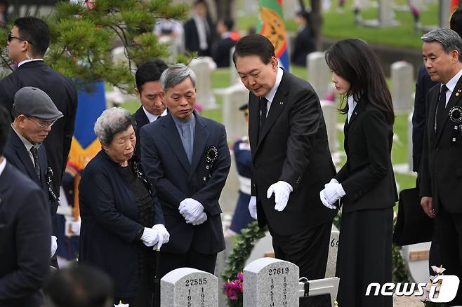 윤석열 대통령과 김건희 여사가 6일 오전 서울 동작구 국립서울현충원 52묘역에서 6‧25전쟁 전사자 故 김봉학 육군 일병의 유해를 안장하는 '호국의 형제' 안장식에 참석해 유가족과 고인의 묘비를 보며 대화하고 있다. 고 김봉학 일병의 유해는 동생인 고 김성학 육군 일병 묘역에 합동 안장됐다. 형제는 6‧25전쟁에 참전한 지 73년 만에 유해로 상봉했다. (대통령실 제공) 2023.6.6/뉴스1 ⓒ News1 안은나 기자