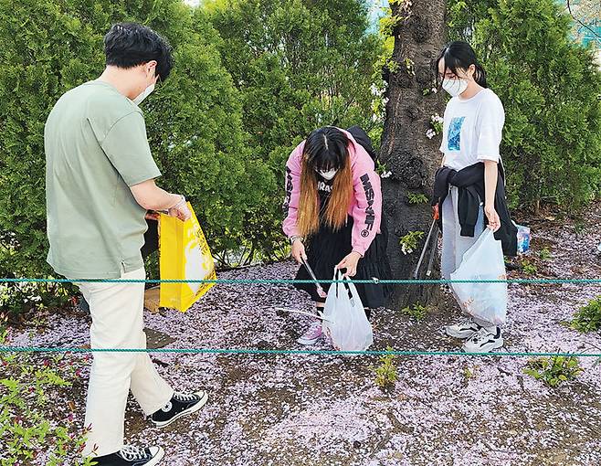 지난해 5월 대학생 연합 환경동아리 ‘에코로드’ 회원들이 손에 집게와 봉지를 들고 서울 광진구 건국대 캠퍼스에서 ‘플로깅’(걷거나 뛰면서 쓰레기도 줍는 활동)을 하고 있다. 에코로드 제공