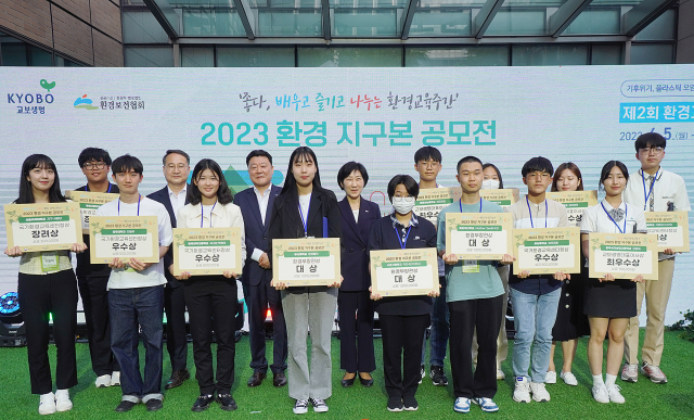 교보생명이 환경의 날과 제2회 환경교육주간을 맞아 5일 서울 종로구 교보생명빌딩 야외 무대에서 ‘환경 교육 북콘서트’를 개최했다. 한화진(뒷줄 왼쪽 네 번째) 환경부 장관과 편정범(〃 세 번째) 교보생명 대표이사 사장이 ‘2023 환경 지구본 공모전’ 수상자들과 기념 촬영을 하고 있다. 사진 제공=교보생명