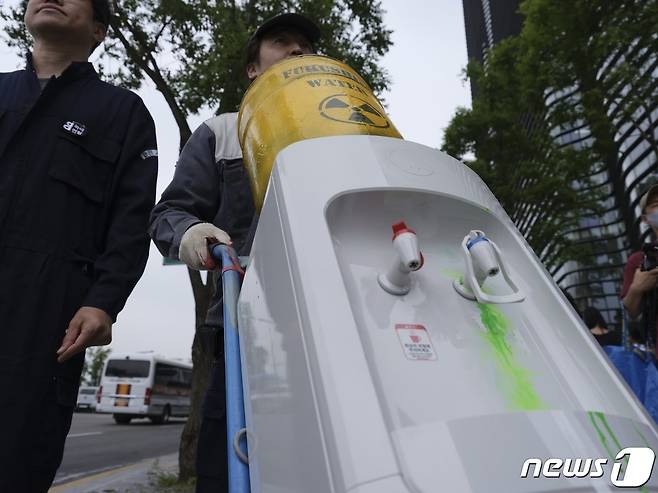 이제석 이제석광고연구소장과 황인철 녹색연합 기후에너지 팀장이 7일 오후 일본대사관에 핵오염수 정수기 모형을 전달하고 있다.(녹색연합 제공) ⓒ 뉴스