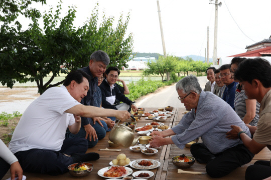 윤석열 대통령이 7일 충남 부여군 임천면의 '꿈에영농조합법인' 모내기 현장을 방문, 모내기를 마친 뒤 주민들과 새참을 함께하고 있다. 대통령실 제공