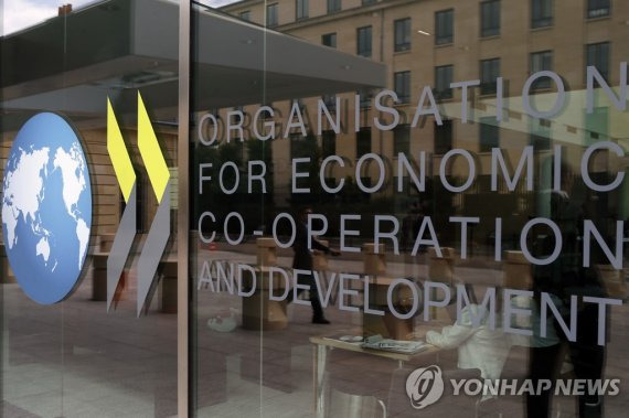 FILE - The logo at the entrance of the Organisation for Economic Co-operation and Development (OECD) headquarters in Paris, June 7, 2017. The OECD on Monday, Sept. 26, 2022 says Russia’s war in Ukraine and the lingering effects of the COVID-19 pandemic are dragging down global economic growth more than expected and driving up inflation that will stay high into next year. The Paris-based organization projects worldwide growth to be a modest 3% this year before slowing further to just 2.2% next year, representing around $2.8 trillion in lost global output in 2023. (AP Photo/Francois Mori, file) FILE PHOTO