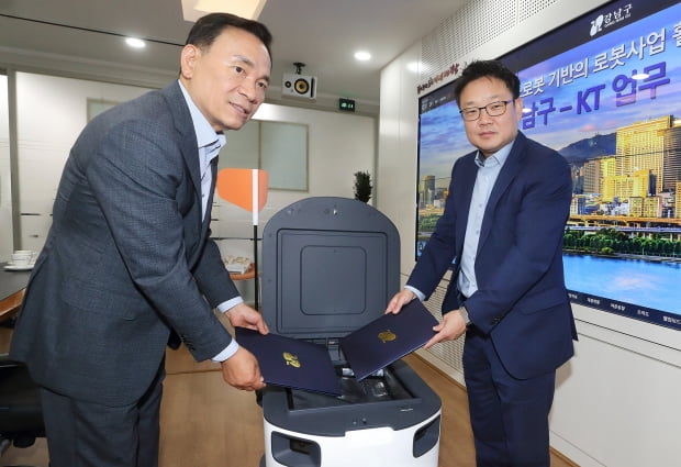 이상호 KT AI로봇사업단장(오른쪽)과 김효섭 강남구청 디지털도시과장이 7일 ‘실외 로봇배송 서비스 제공’에 대한 업무협약(MOU)을 맺고 있다. KT 제공