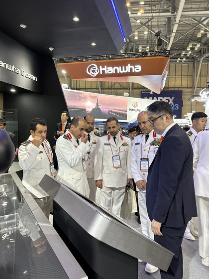 A delegation from Saudi Arabia listens to explanation at the Hanwha Ocean exhibition booth at Madex 2023 in Busan on Wednesday. [SEO JI-EUN]