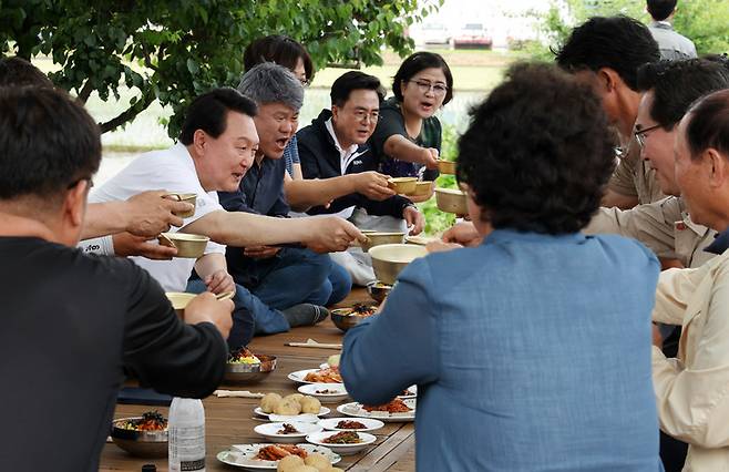 [서울=뉴시스] 윤석열 대통령이 7일 충남 부여군 임천면 꿈에영농조합법인을 방문해 모내기를 마친 뒤 주민들과 새참을 먹고 있다. (사진=대통령실 제공) 2023.06.07. photo@newsis.com *재판매 및 DB 금지