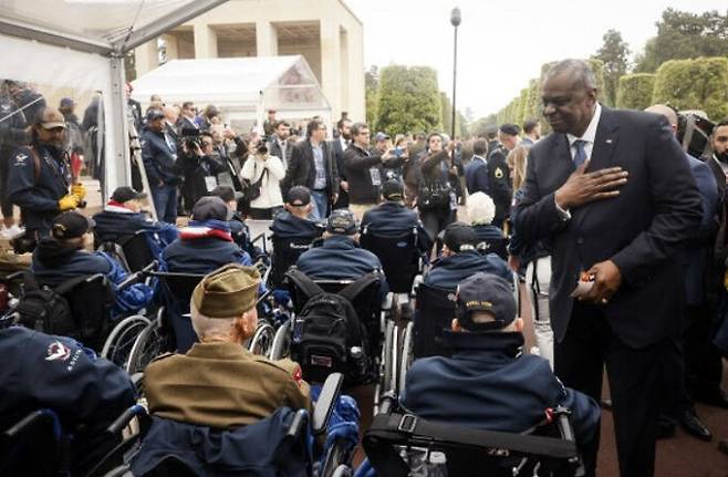 로이드 오스틴 미국 국방장관(오른쪽)이 노르망디 상륙작전 79주년을 맞아 6일(현지시간) 프랑스 노르망디에서 열린 기념행사에 참석해 참전용사들한테 경의를 표하고 있다. AP연합뉴스