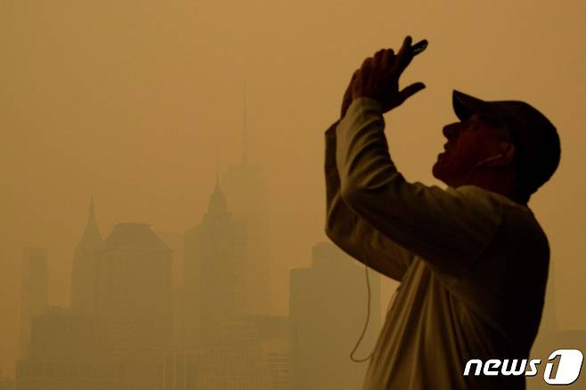7일 (현지시간) 캐나다에서 발생한 산불의 영향으로 연기로 덮여 뿌연 뉴욕의 모습을 주민이 사진을 찍고 있다. 2023.6.8 ⓒ AFP=뉴스1 ⓒ News1 우동명 기자