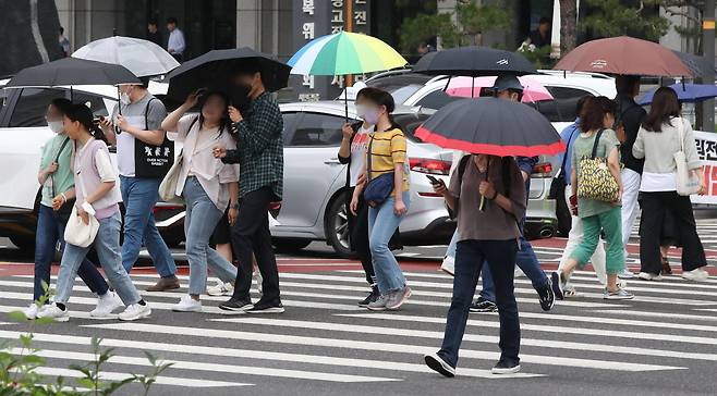 8일 오후 서울 중구 서울시청 인근에서 시민들이 우산을 쓰고 걸어가고 있다./뉴시스