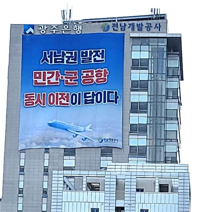 전남개발공사 건물 외벽에 '서남권 발전 민간·군공항 동시 이전이 답이다'를 알리는 대형 현수막이 내걸려 있다. 뉴시스